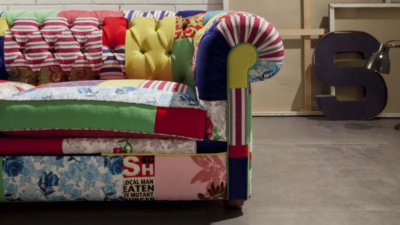 Il rivestimento è un patchwork di vari tessuti che rende questo divano chester multicolore